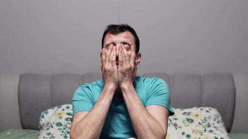 Un homme est couché tard dans la nuit, se retourne et ne peut pas dormir, souffre d'insomnie.