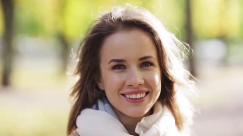 Belle jeune femme souriant joyeusement dans un parc d'automne profitant de la saison d'automne