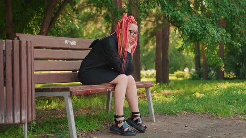 Pensive Lady on Park Bench Solitary Female with Colorful Hair in Tranquil Park Woman with Vibrant