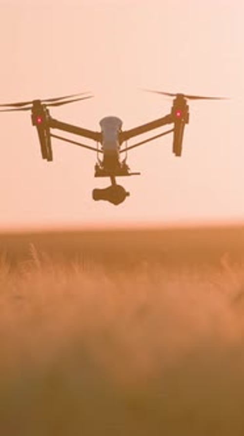 A Captivating Aerial View of a Drone Gracefully Soaring Through the Beautiful Sunset Sky