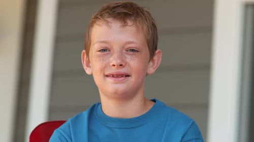 Smiling Boy Holding American Flags on Porch