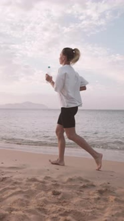 Morning Jog on Sandy Beach in Summertime Young Woman Running Alone in Sunrise Healthy Lifestyle and