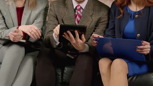 Closeup of Businessman and Female Coworkers with Tablet Pc Discussing Strategy