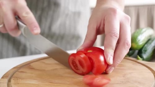 Tomato slicing on a wooden board, close up