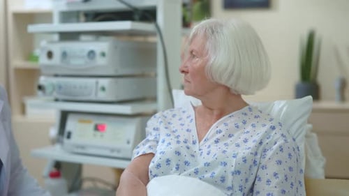 Doctor Examines Senior Woman in Hospital Setting