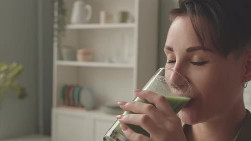 Brunette Woman Drinking Green Smoothie