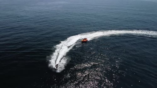 Jet Ski Pulling Tube Riders in Ocean Aerial