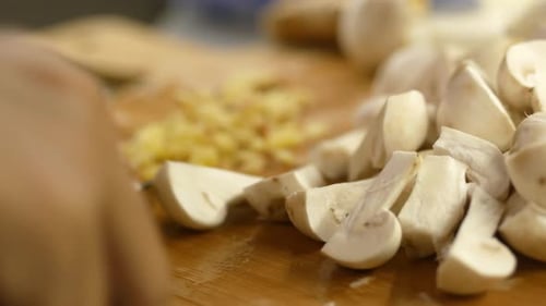 Hand Slicing Mushrooms on Cutting Board
