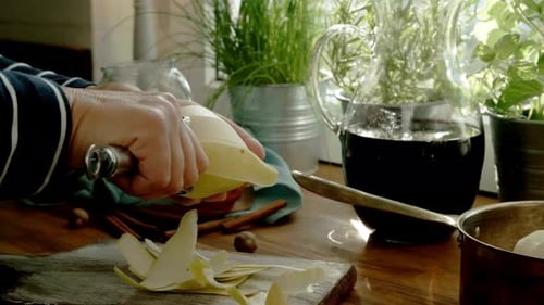 Close-up of Hands Peeling a Fresh Pear in a Sunlit Kitchen