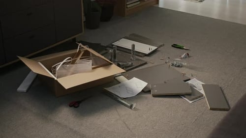 Pièces de l'armoire Flatpack éparpillées sur le sol pendant le processus d'assemblage