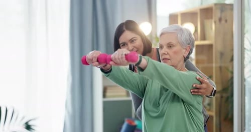 Supportive Woman Helping Senior Exercising with Dumbbells