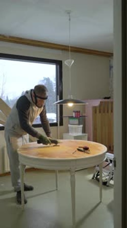 Man Refinishing Table in Home