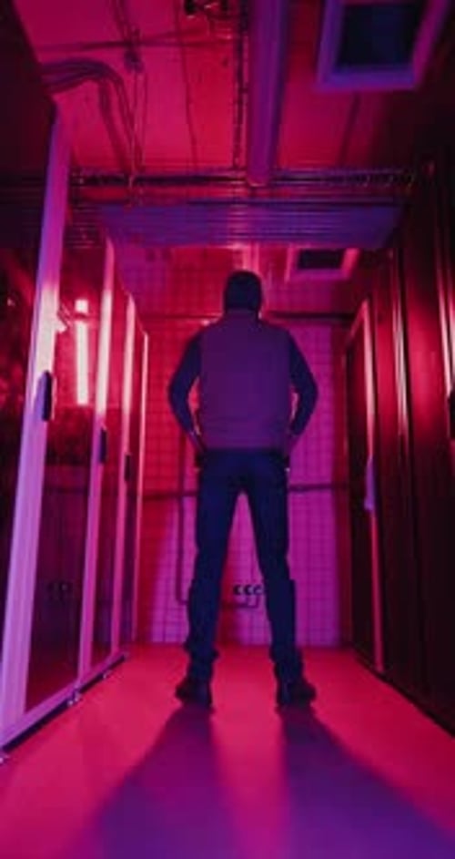 Figure Standing in a Futuristic Server Room at Night