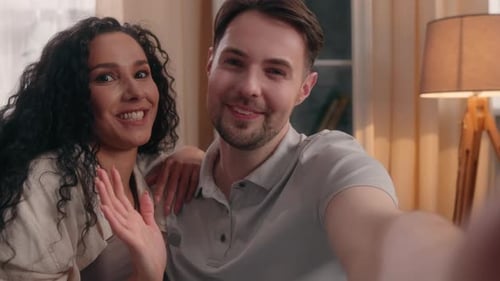 Happy Couple Smiling and Waving in their Home