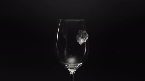 Frozen Blocks Falls Empty Glass Closeup. Ice Cubes Throw At Transparent Wineglass In Super Slow M...