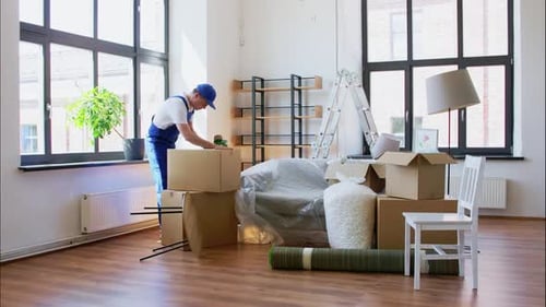 Man moving cardboard boxes in an empty apartment