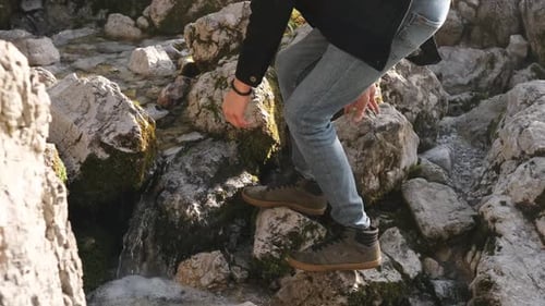Man Traveler Drinks Clean Water From River or Spring in Autumn Forest