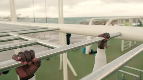 Close-up of doing pull-ups on a horizontal bar outdoors