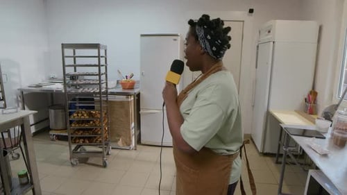 Baker Speaks into Microphone in Commercial Kitchen