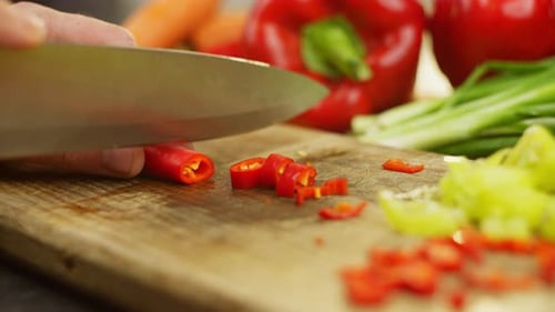 Person Chopping Peppers on Cutting Board Close Up