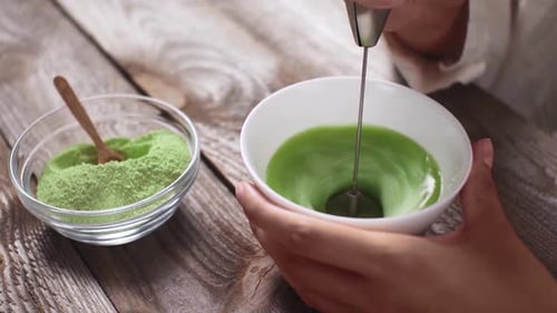 matcha tea Woman preparing summer refreshing drink, Whipping green tea preparing drink