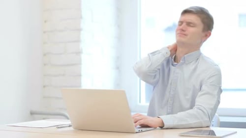 Young Adult with Neck Pain Using Laptop in Office