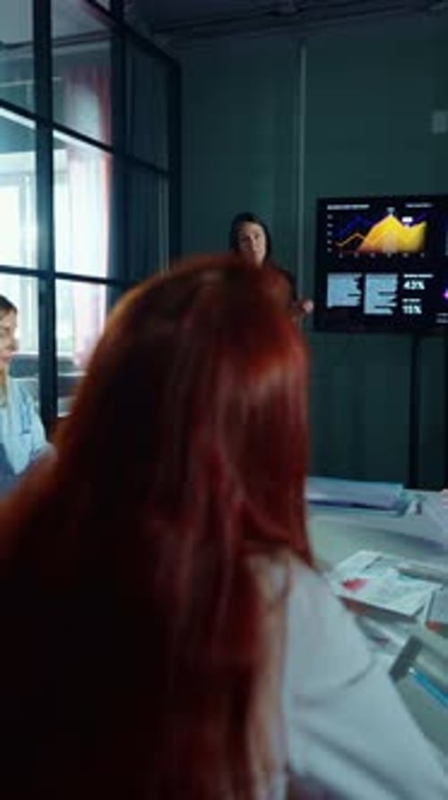 Businesswoman Presents Data to Colleagues in Modern Office