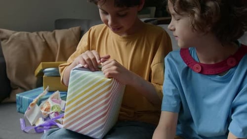 Children opening birthday presents at home party