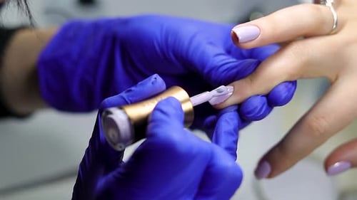 Applying Light Purple Nail Polish with Gentle Strokes