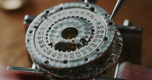 Slow motion close up of a professional watchmaker repairer working on a luxury mechanism watch gea