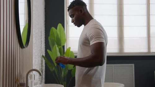 African American Guy Ethnic Man Cleaning Teeth at Home Tidy Man Rinse Mouth with Antibacterial