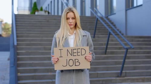 Fired Caucasian Female Manager Holding a Cardboard Sign Reading Need Job to Highlight Jobless