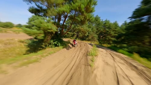 Motorcyclist Riding Dirt Bike in Rural Landscape
