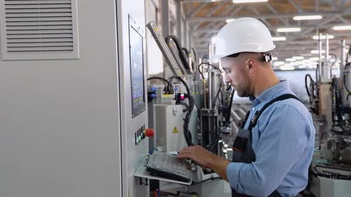 Industrial Worker Wearing Safety Uniform and Helmet Indoors in Factory