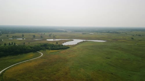 Drohnenweite Aufnahmen eines Feldes mit einem Fluss und einem Wanderweg