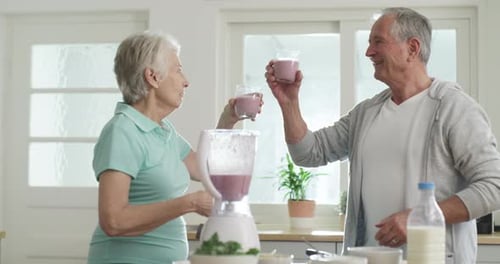 Senior Couple Makes a Smoothie Together in Kitchen