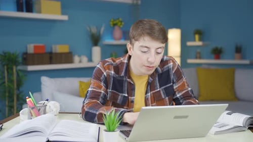 Tired Young Adult Studying at Home Desk
