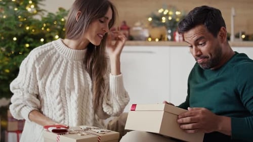 Couple Opening Christmas Presents at Home