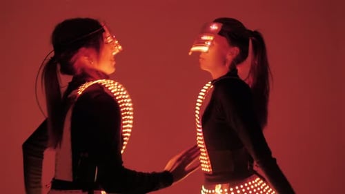 Two Disco Dancers Move in UV Costumes