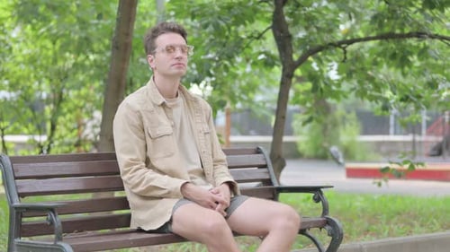 Young Adult Sitting on a Bench in Park
