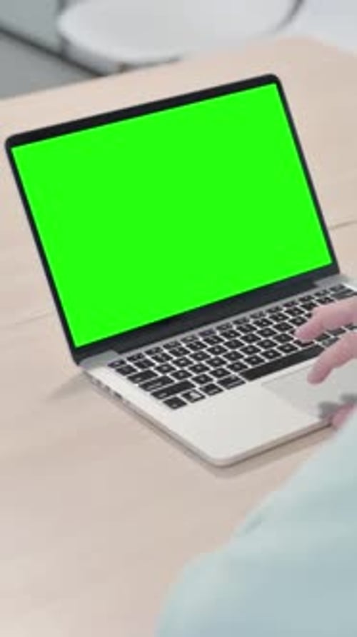 Young Man Using Laptop with Green Screen, vertical video