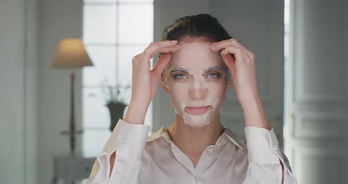 Beauty shot of young woman is taking off paper sheet mask from her purified and clean face touchin