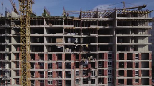 Kran liefert Baumaterial für Arbeiter zum Bau eines Wohnhauses
