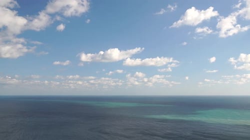 Aerial View on Azure Sea with Fluffy Cumulus Clouds Moving in Bright Sunset Sky Over Calm Sea Nature