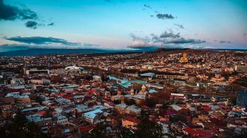 Time-lapse: Top view of Tbilisi at night. Capital of Georgia. City coming to life. Popular travel de