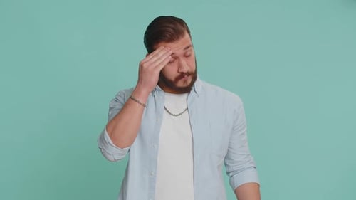 Young Man Massaging Temples in Discomfort
