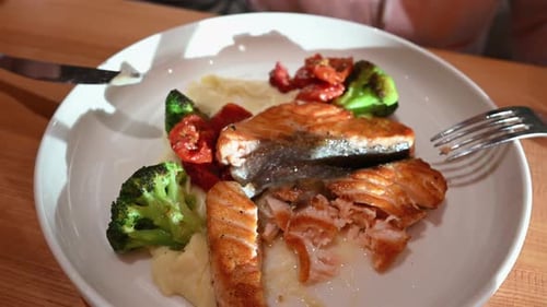 Salmon Fillet with Vegetables Being Cut for Meal