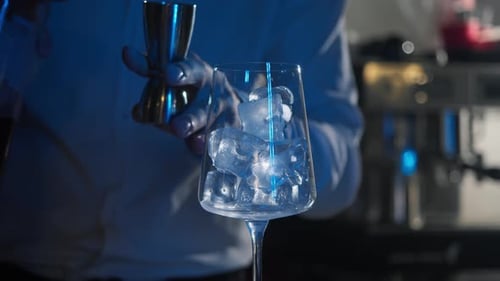 Bartender preparing an alcoholic cocktail in a glass