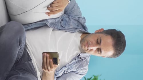 Man Using Smartphone While Sitting on Couch