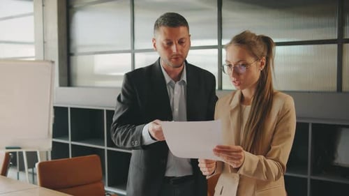 In a Contemporary Office a Team of Professionals are in a Meeting Discussing Documents and